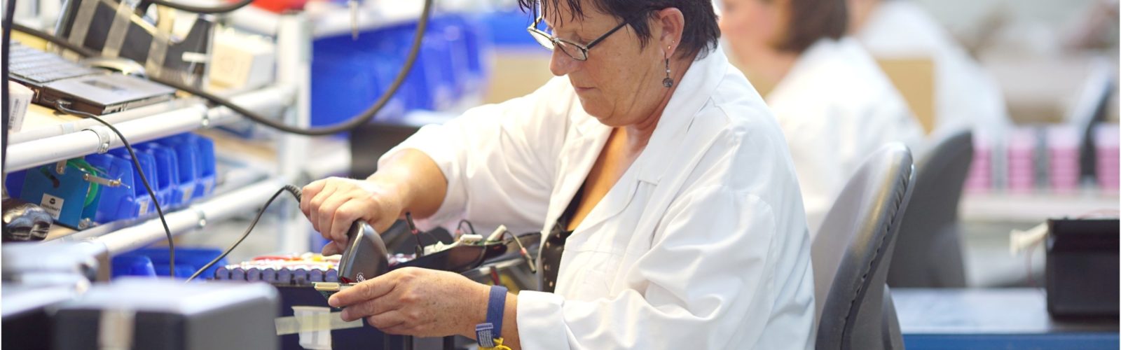 Une personne scanne le code barre d'une batterie sur une ligne de production